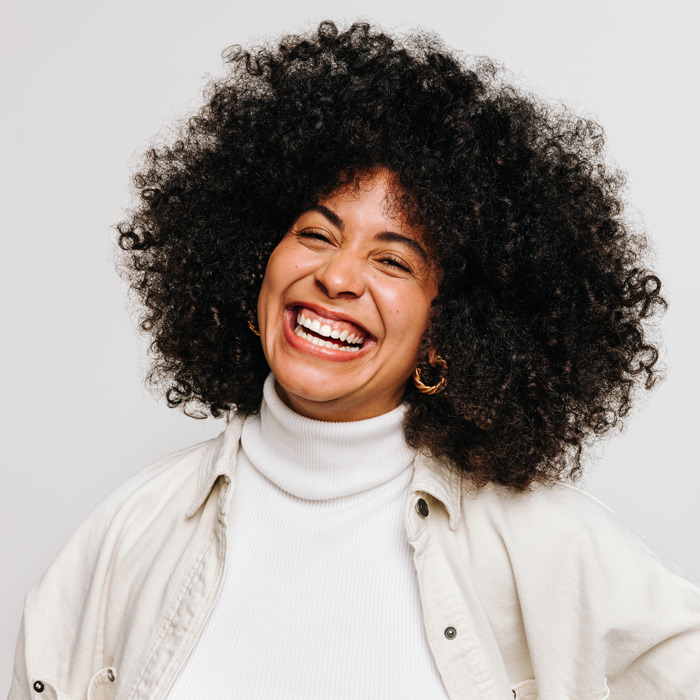 Happy young woman of color smiling at the camera in a studio