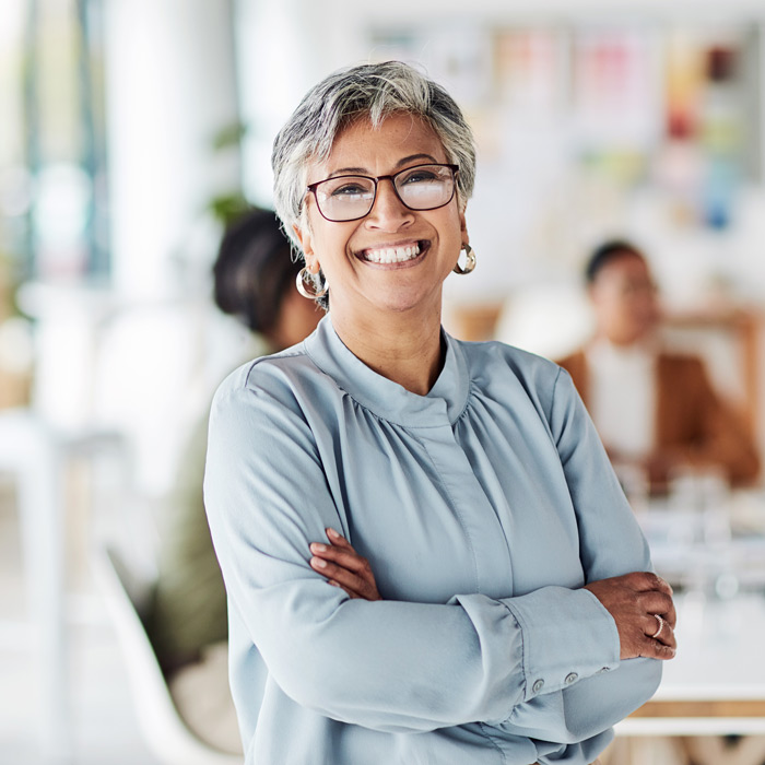 business woman in the office with crossed arms, smiling