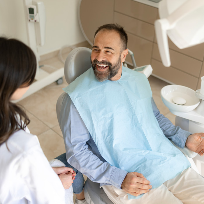 Happy male patient talking to his dentist in medical clinic