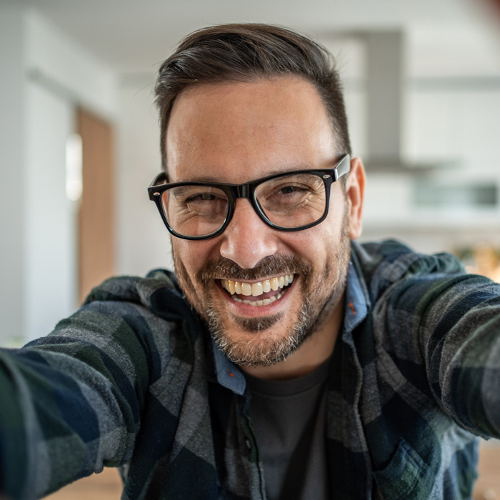 smiling man taking a selfie at home