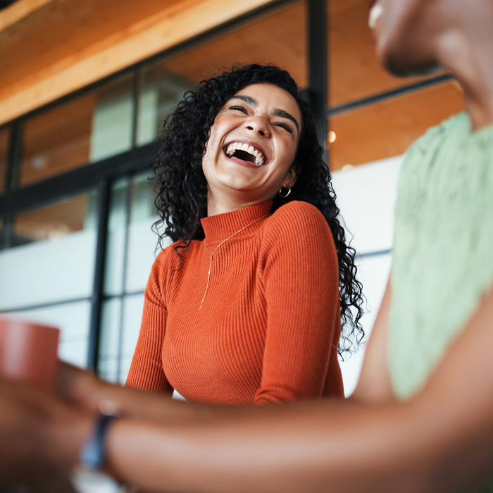 woman laughing while talking to friend