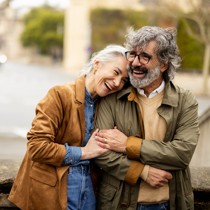 senior couple laughing and embracing while on a walk