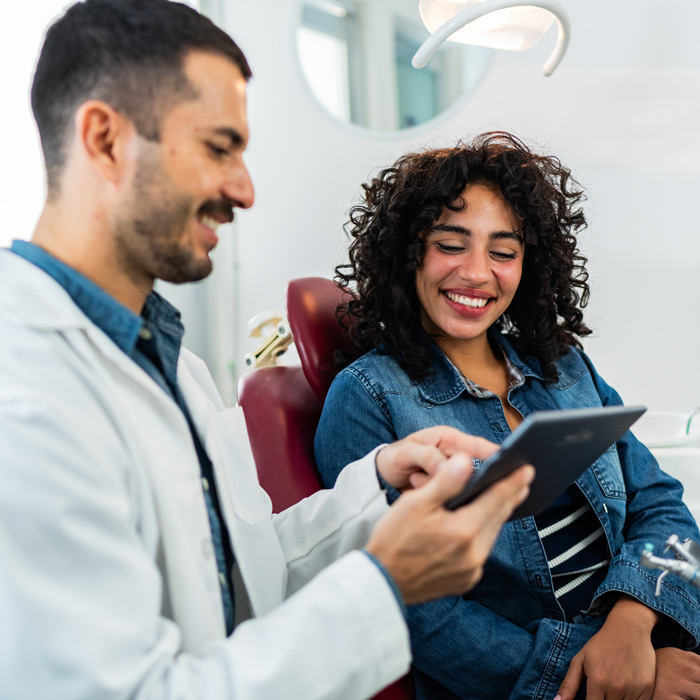dentist showing patient data on a tablet
